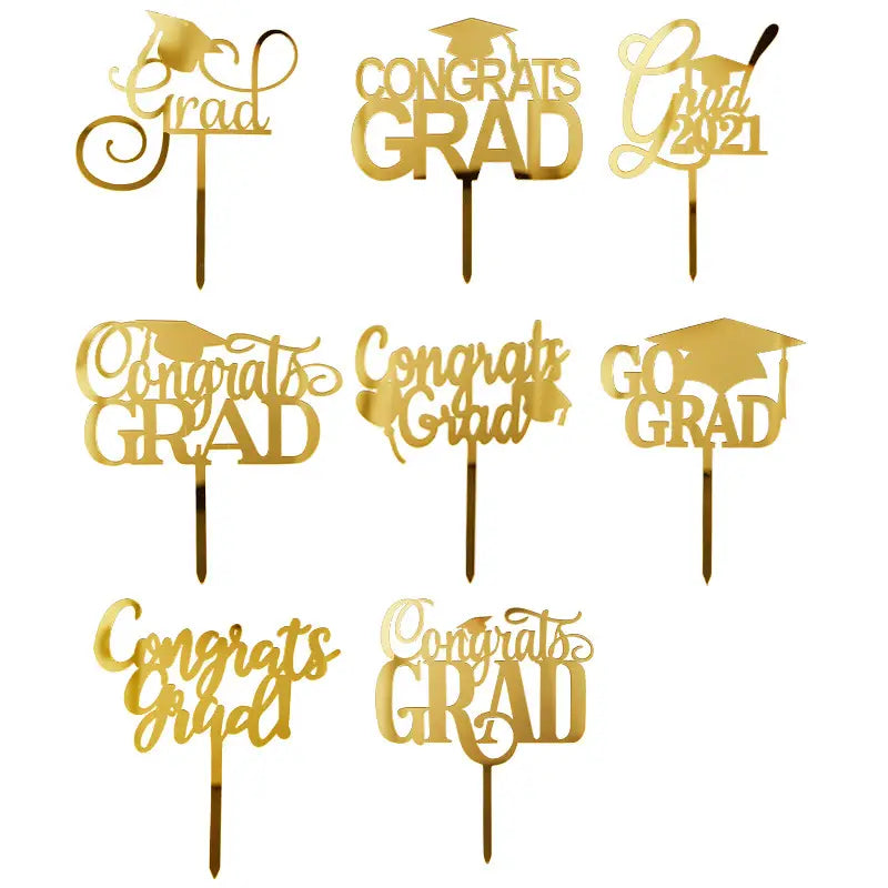 Gold acrylic graduation cake topper featuring gold-colored elegant script and mortarboard designs.