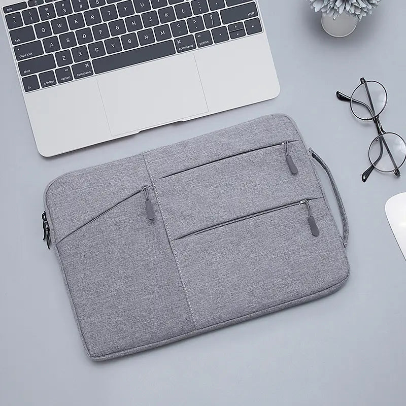 Gray textured laptop sleeve bag with multiple zippered compartments and carrying handle designed for MacBook Air and Pro models.