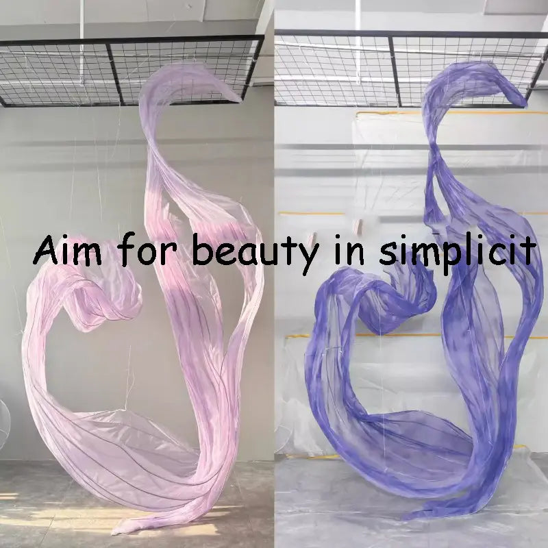 un telón decorativo de guirnalda floral gigante de gasa que presenta un fondo decorativo con forma de flor, con una escultura fluida y translúcida de tela semitransparente en un degradado de tonos rosados suaves a lavanda