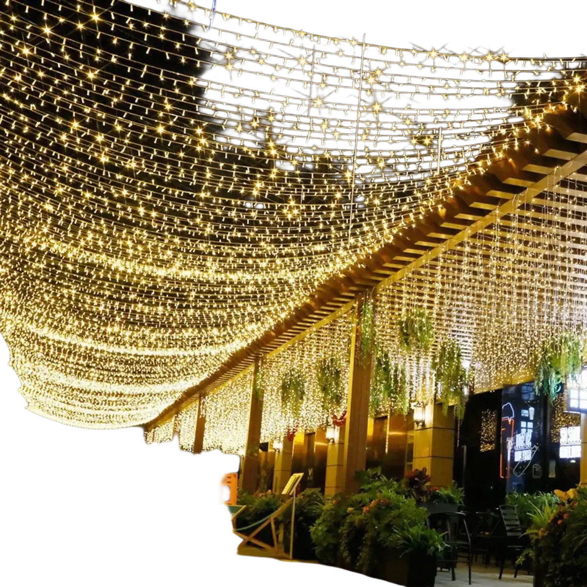 Luces en forma de guirnalda de hadas LED con control remoto en un color dorado cálido, dispuestas con un patrón en cascada de estrellas sobre una terraza al aire libre, en vista nocturna.