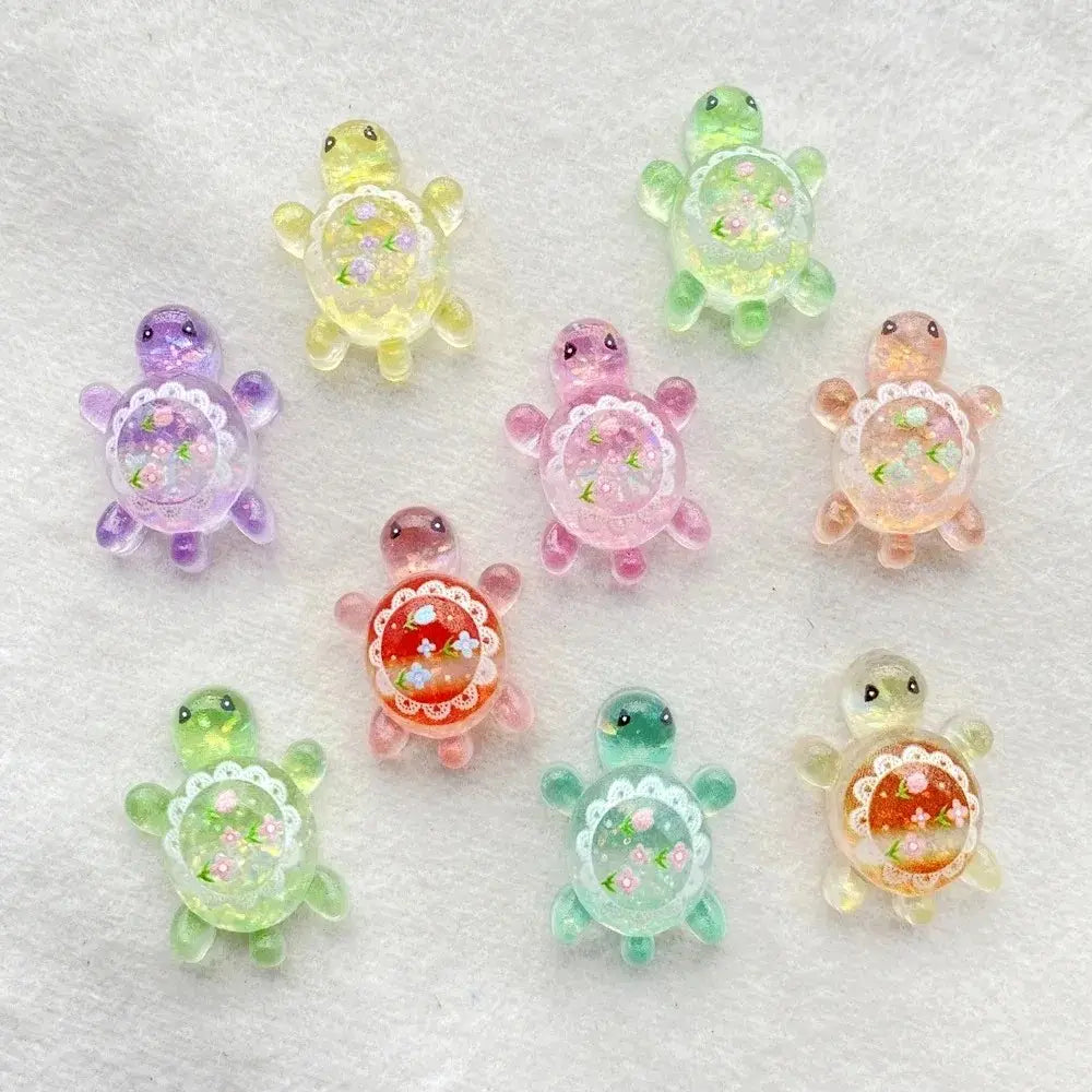 Resin turtle flatback charms 10 pack featuring pastel-colored resin with floral glitter details and lace-like borders.