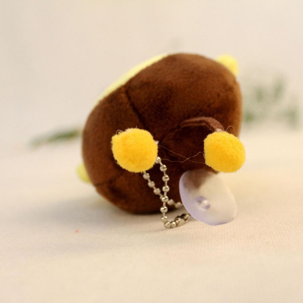 brown bee stuffed animal plush toy with yellow pom-pom ears and a silver chain attached to its back showing the back side of the stuffed animal