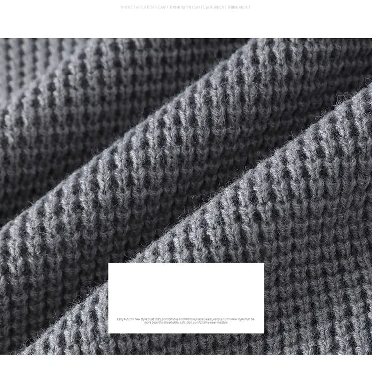 Ein weicher, strukturierter grauer Strickschal mit geripptem Muster, kombiniert mit einem Moownuc Herren-Waffelstrick-Pullover im lässigen Stil.