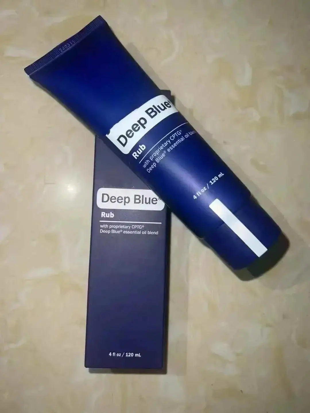 a deep blue essential oil blend 120 ml tube in sleek navy blue with white labeling alongside a matching box for deep blue rub therapy