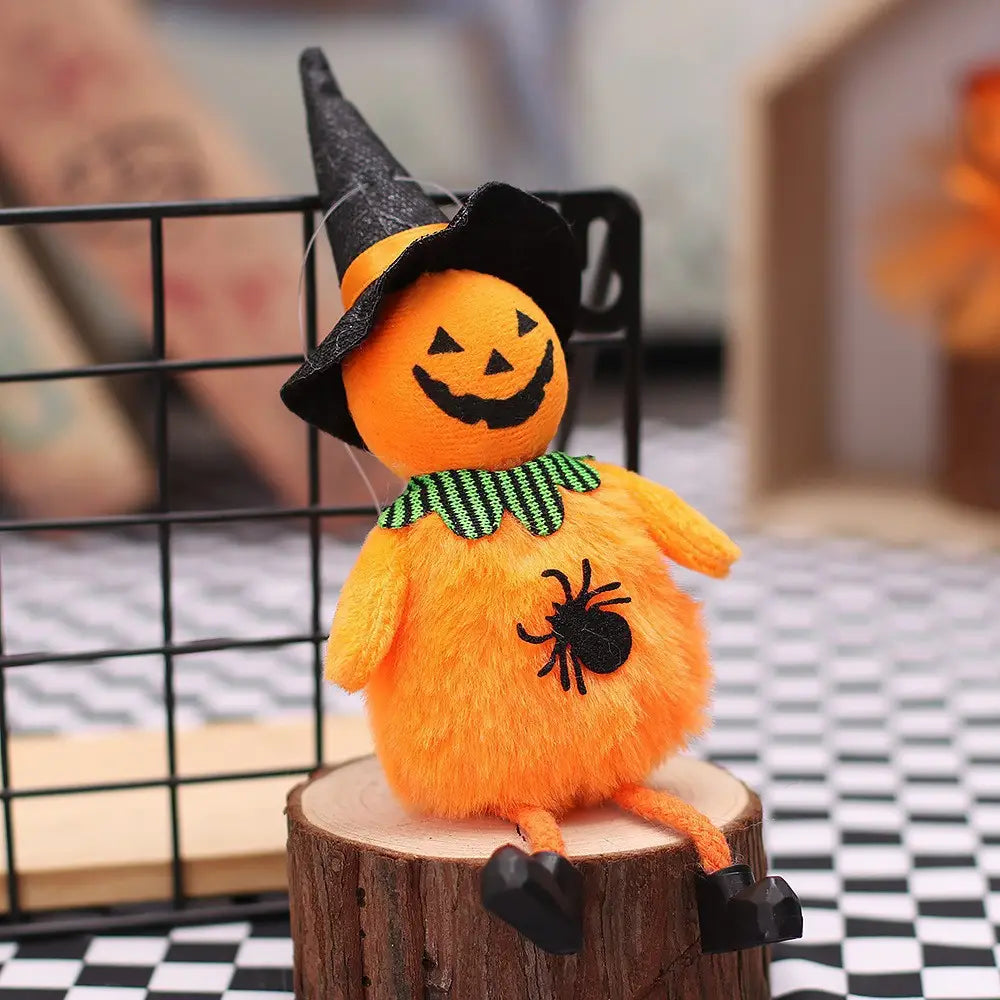 Figura de tela de adorno de halloween de calabaza naranja de felpa, con un sombrero de bruja negro y una bufanda verde con un aplique de araña negra como colgante, figura de tela para halloween.