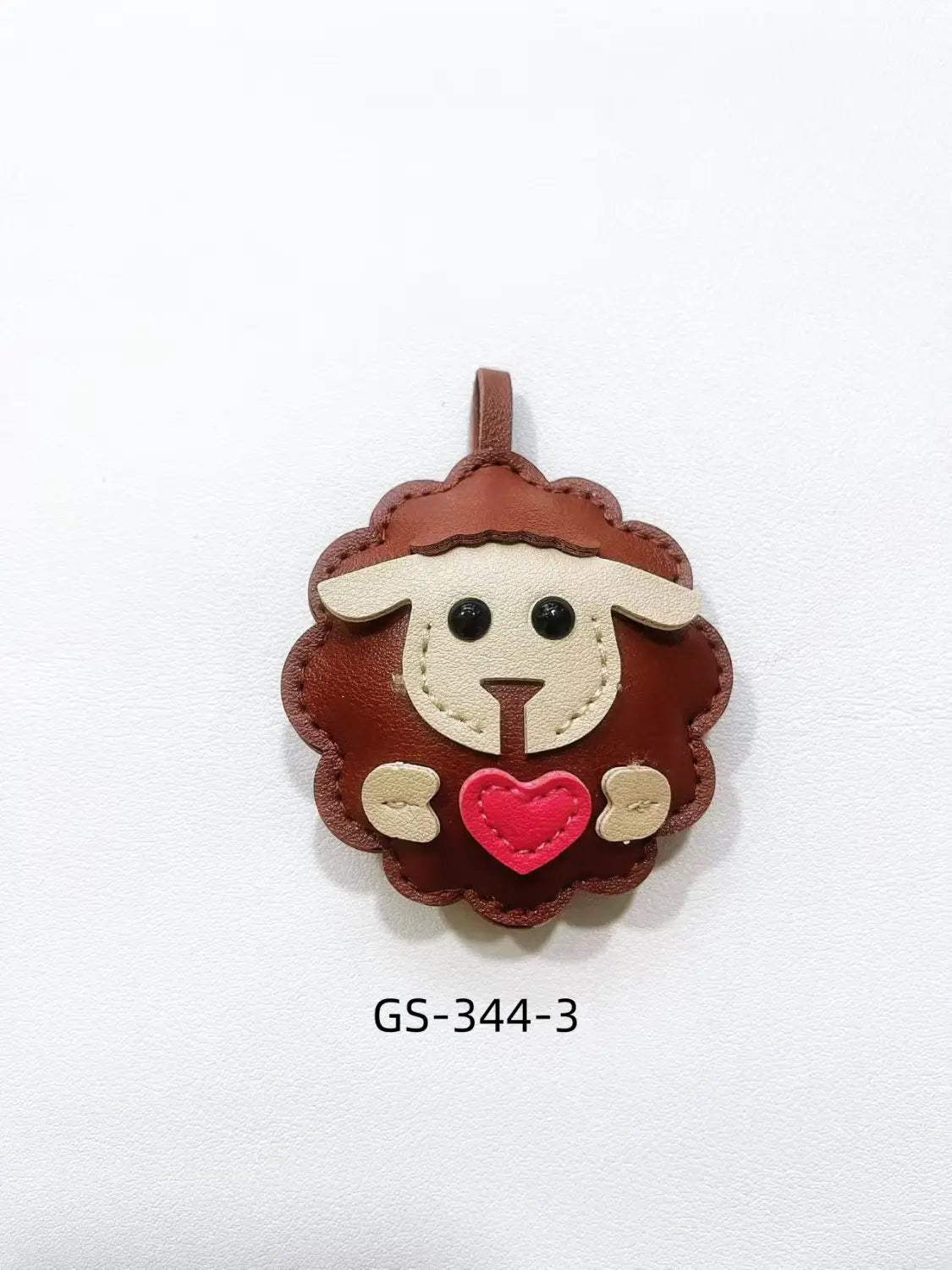 Brown leather sheep keychain with cream-colored face black button eyes and red heart stitched on chest for cute animal bag charm.