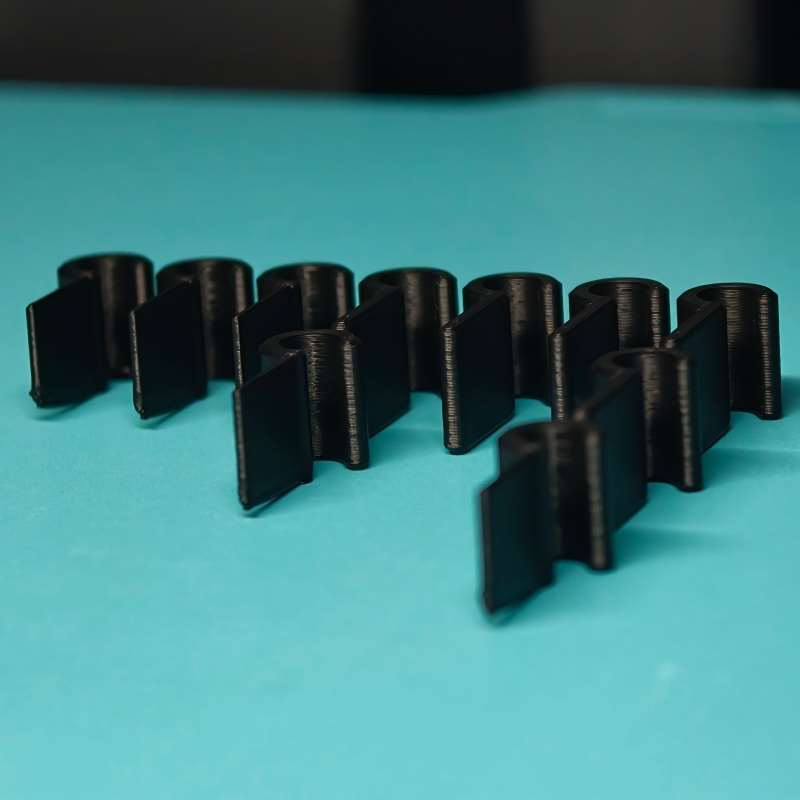 pinces de câble pour tableau de bord de voiture imprimées en 3D noires, organisateurs de câbles à emboîtement s’emboîtant l’un dans l’autre, finition mate et lignes de couche visibles.