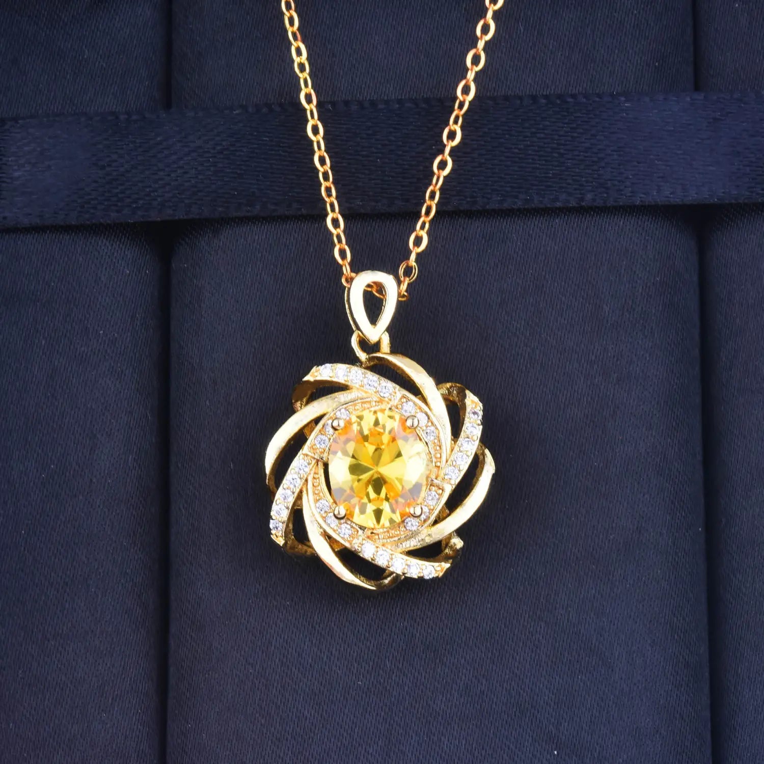Collier pendentif doré en or, moulin à vent en citrine, comportant une pierre précieuse jaune centrale en citrine entourée d’un entrelacs doré tourbillonnant et de petits diamants transparents, dans un design de collier pendentif moulin à vent en citrine, collection de pierres de naissance dorées.