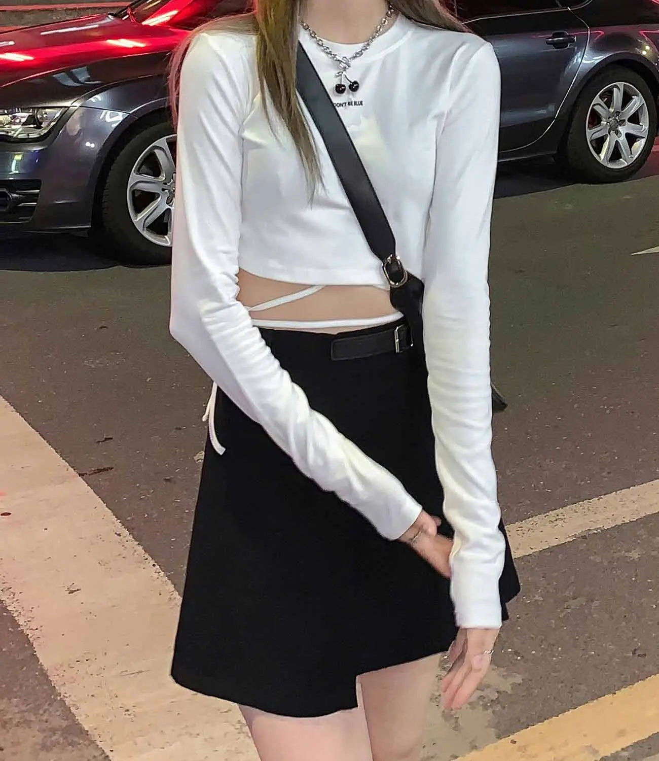 Weißes Damen-Langarm-Crisscross-Crop-Top mit gerippten Bündchen und dezentem Cutout-Detail vorne.