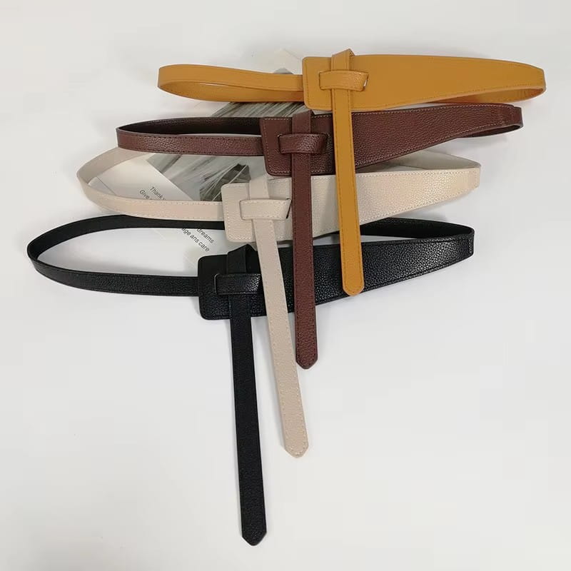 Eine Kollektion von Damen-Gürtelbändern aus weitem PU-Leder in Hellbraun, Braun, Beige und Schwarz mit minimalistischen passenden Schnallendesigns.