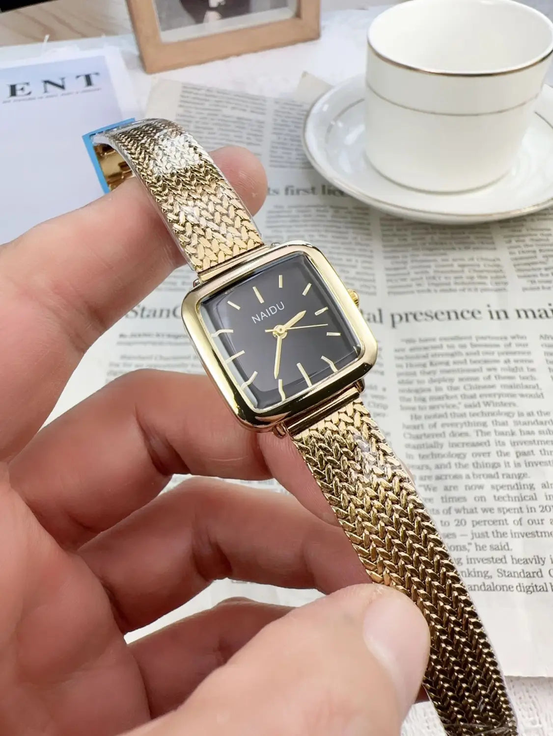 Gold-toned minimalist square quartz watch for women with a black dial and mesh strap by nai du.