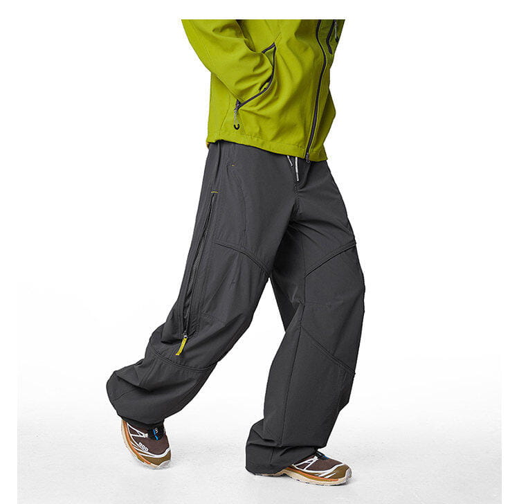 pantalones cargo impermeables de senderismo para hombre en gris oscuro, con tejido resistente, que incluyen múltiples bolsillos con cremallera y tiradores de cremallera amarillos, diseñados para secado rápido y uso en exteriores.