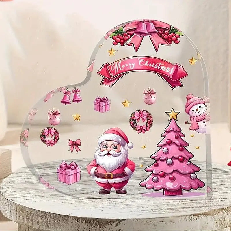 Rosa weihnachtlich inspiriertes klares Acrylherz-Ornament mit Santa und Baum auf einem Desktopständer zur festlichen Dekoration.