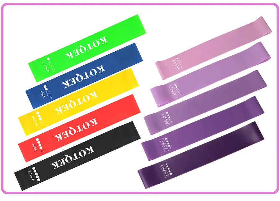 Set of colorful kotoek resistance bands including vibrant green blue yellow red black and various shades of purple designed for home fitness use.