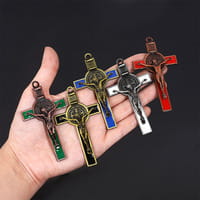 Hand holding five colorful metallic crucifixes with engraved details showcasing varied finishes related to saint Christopher leather keychain antique bronze.