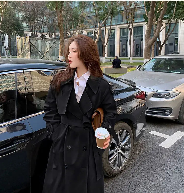 women double breasted trench coat featuring a black belted waist and double-breasted front in a classic trench design