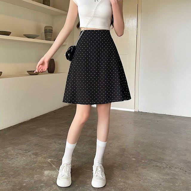Falda línea A negra con lunares blancos y pretina ajustada en una ficha de producto de falda midi línea A roja con lunares.