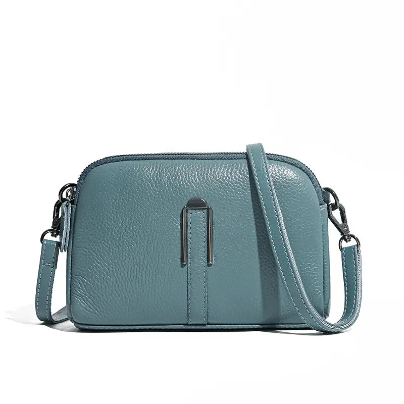 Elegante Umhängetasche aus echtem, tealfarbenem Leder für Damen mit strukturierter Oberfläche und silberfarbenem Metallschnallenverschluss.