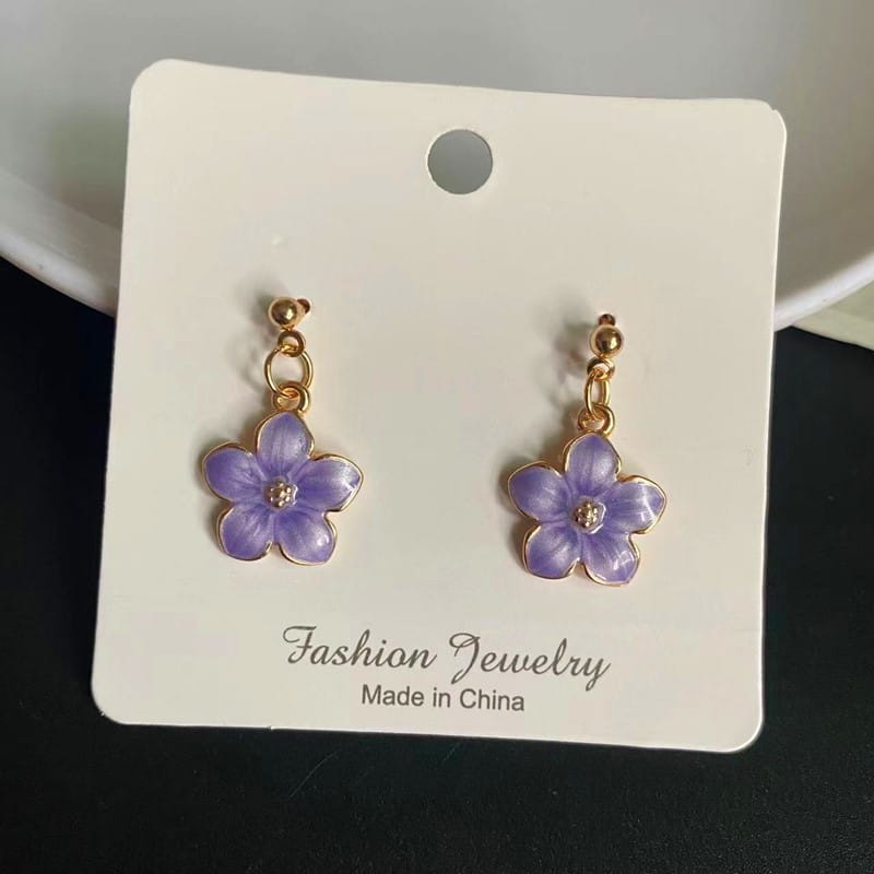 Boucles d’oreilles en forme de fleur émaillée violette, avec des attaches en métal à l’aspect doré et une petite pierre transparente au centre ; complètent un collier pendentif de fleur romantique et mignon avec une chaîne à maillons.