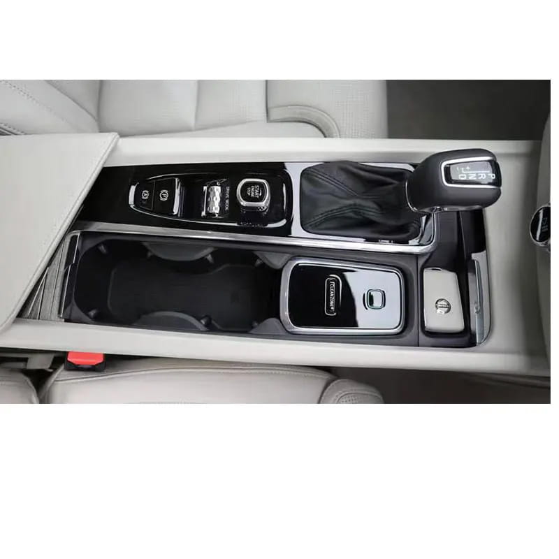 Volvo Cleanzone wireless car charger and air purifier with black and silver glossy center console trim featuring integrated cup holders control buttons and gear shift knob.