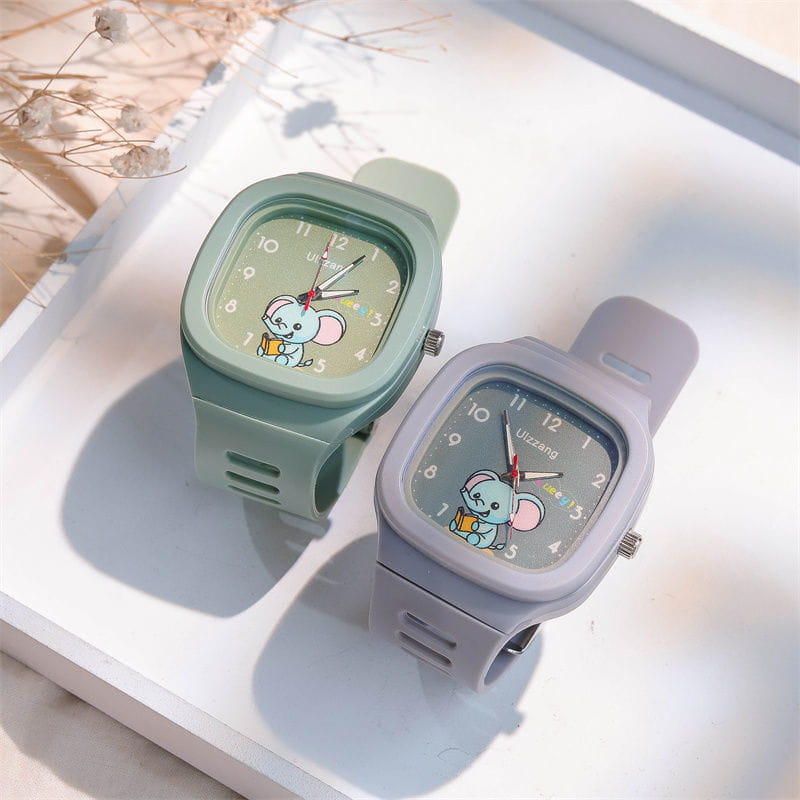 Two pastel-colored luminous children’s digital watches with square faces and cartoon mouse designs on the dials in white straps.