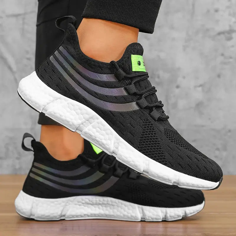 Baskets de sport décontractées en maille respirante pour hommes Zuuban avec dessus en mesh noir, des bandes grises réfléchissantes, des accents vert néon sur la languette et une semelle en mousse blanche.