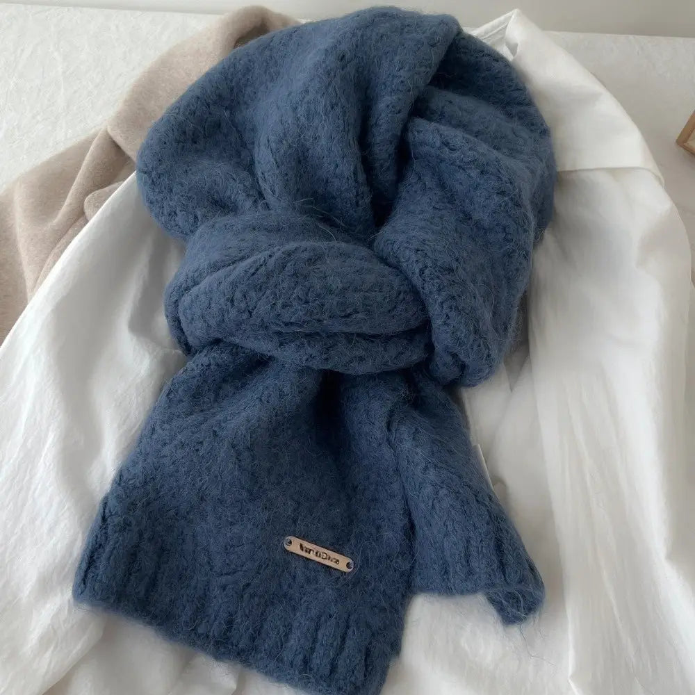 Una bufanda de punto de invierno para mujer color azul marino intenso, con una textura suave y esponjosa y un patrón de trenzado sutil, diseñada como calentador de cuello y chal cálidos.
