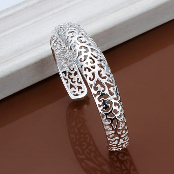 Sterling silver filigree cuff bracelet featuring an open design with intricate swirling patterns and a polished finish.