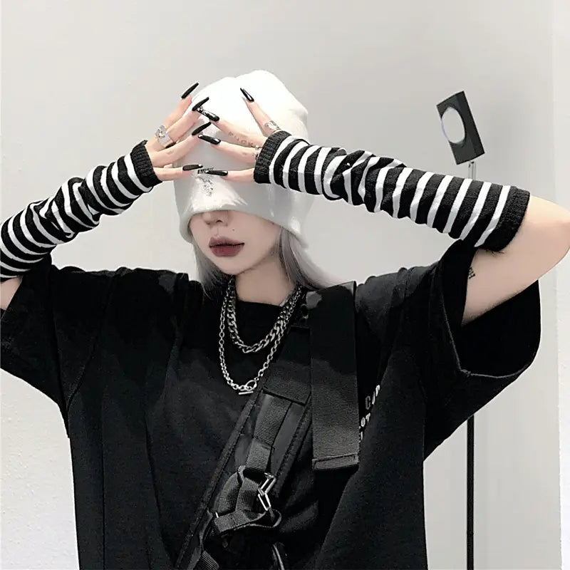 Black and white striped knit fingerless arm warmers with ribbed cuffs and long sleeves.