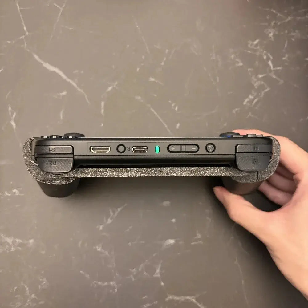Schwarzer tragbarer Gaming-Controller Anbernic RG40XX mit ergonomischem, strukturiertem Griff und leuchtender grüner Betriebsanzeige.