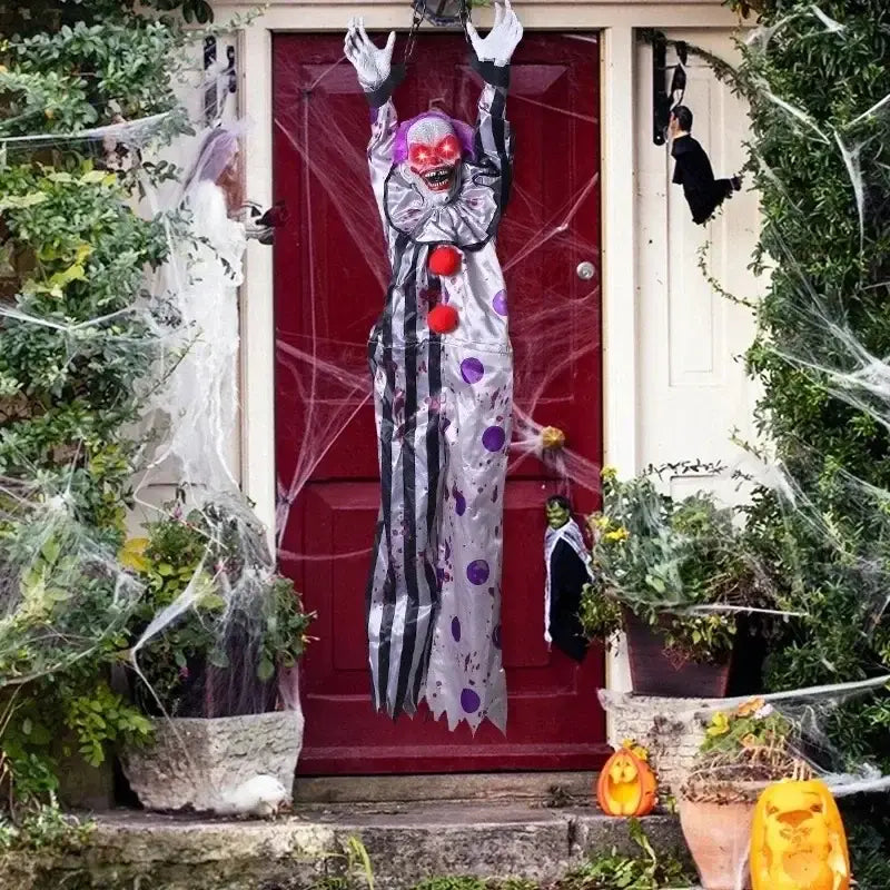 Una figura decorativa colgante de payaso animado con temática de Halloween, con ojos rojos y usando un atuendo plateado y negro a rayas, adornado con puntos morados, pompónes rojos y guantes blancos.