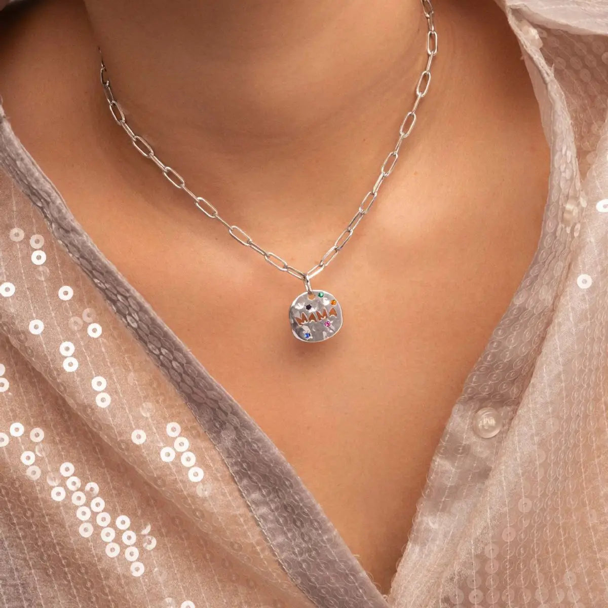 Collier à chaîne en argent avec pendentif rond en acier inoxydable coloré, comportant des pierres précieuses intégrées et le mot « mama » en lettres arc-en-ciel, conçu comme un collier avec pendentif en acier inoxydable de pierre précieuse « Mama ».