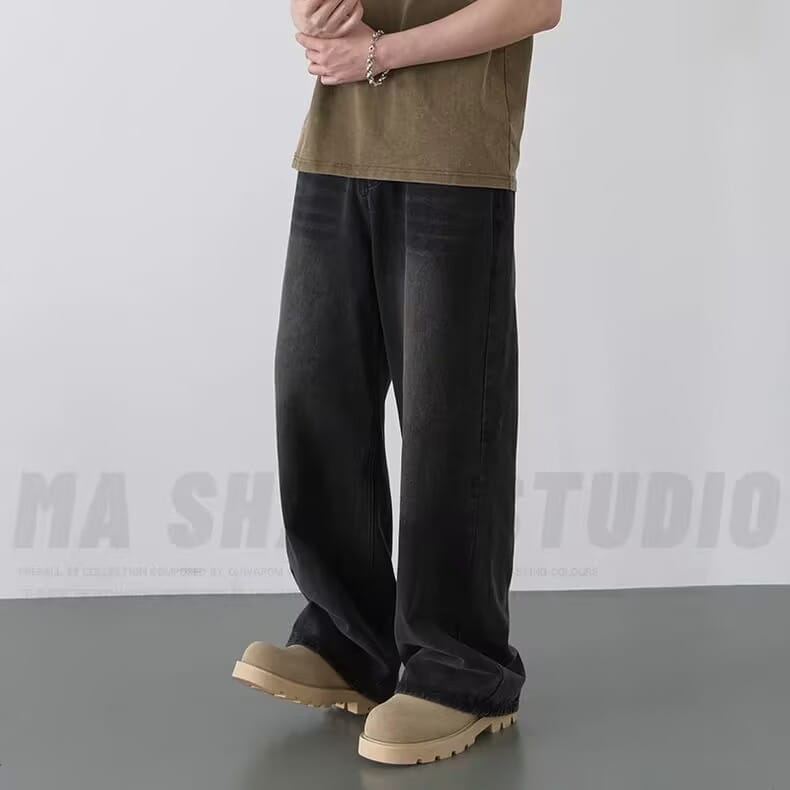耐久性のあるデニム素材で作られた、リラックスしたストレートカットのシルエットを特徴とするブラックのワイドレッグダメージ加工デニムジーンズ。