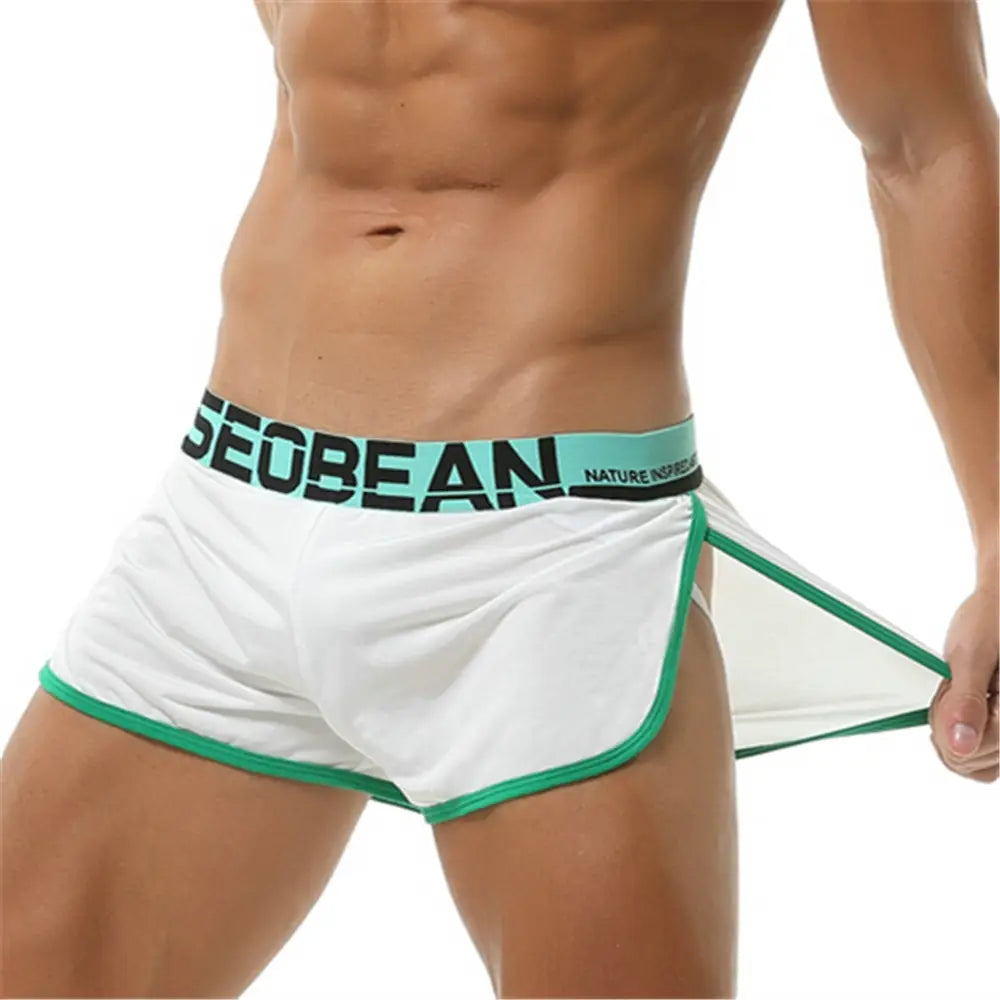 Boxer briefs atléticos transpirables blancos para hombre, con ribete verde y una pretina turquesa, con el nombre de la marca seoban diseñado para ropa de dormir y deportiva de hombres.