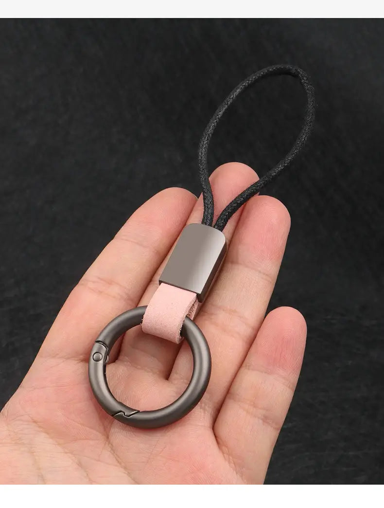 A sleek matte-finished metal carabiner keychain with a soft pink leather strap and a rectangular silver-toned plate for organizing car keys.