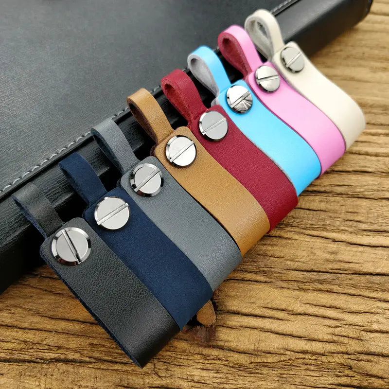 A set of colorful genuine leather car keychains and metal key rings featuring navy gray tan red light blue pink and cream colors with silver-toned screw cap closures.