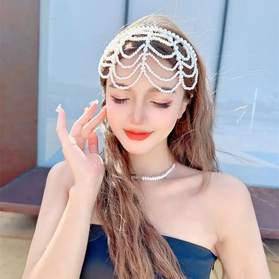 A delicate white pearl bridal crown hair band with an intricate cascading tassel design.
