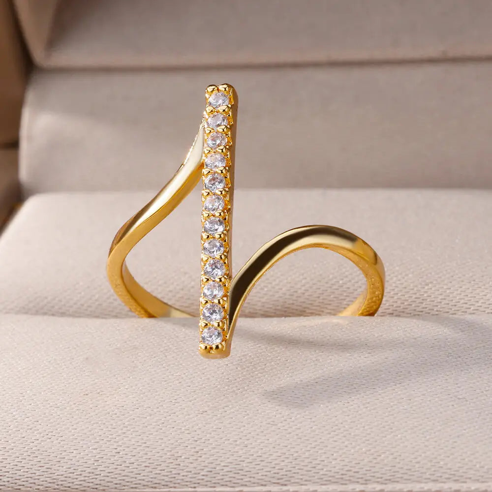 Gold color stainless steel finger ring for women featuring a sleek curved design with a vertical row of clear zircon geometric stones.