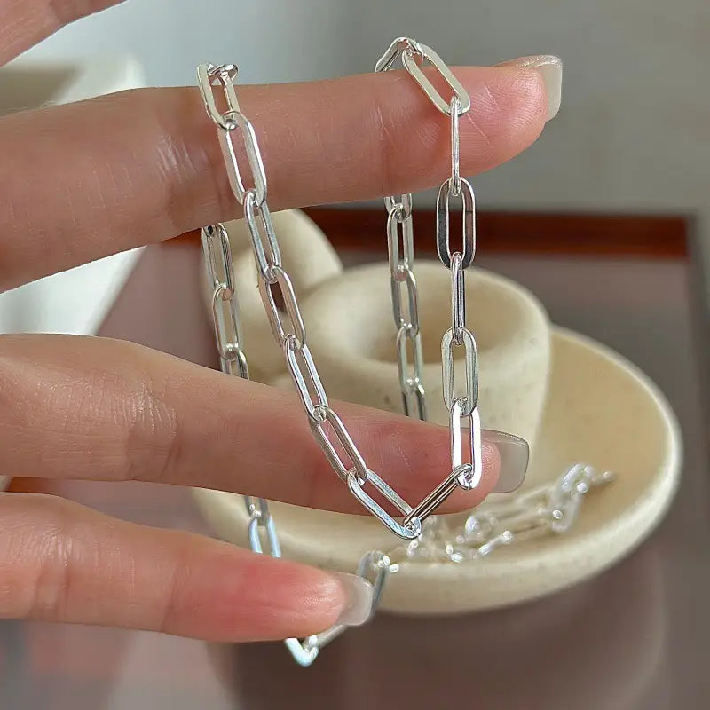 Collar minimalista de cadena tipo eslabones de papel en plata de ley, con un diseño elegante de estilo grapa de papel.