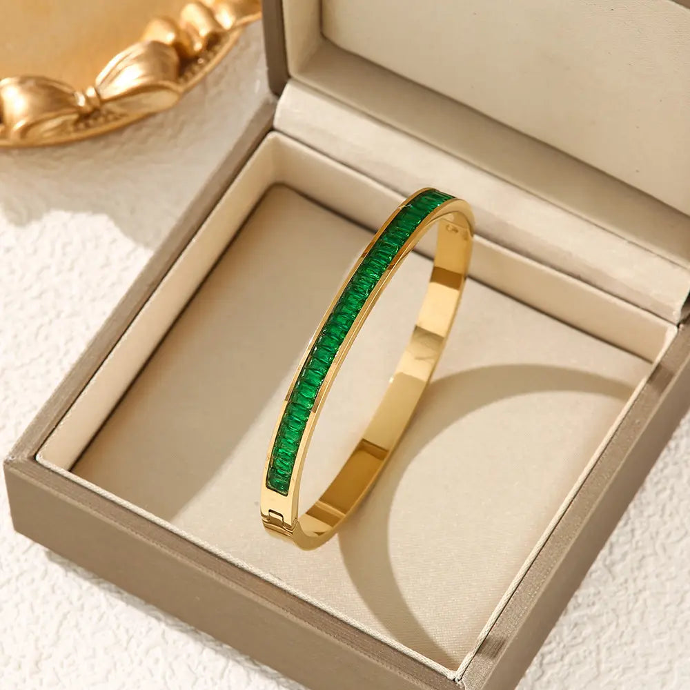 Set aus Armreif aus Goldfarbenem Edelstahl mit Kristallen, verziert mit einer Reihe kräftig grüner, smaragdähnlicher Steine.