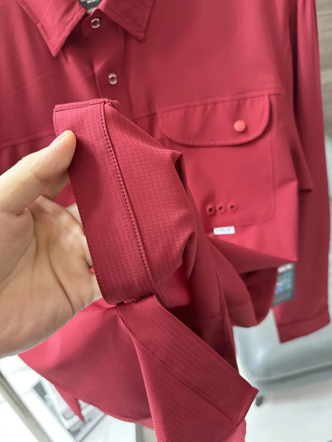 Men’s tactical outdoor long sleeve shirt in rich crimson with a subtle textured weave and matching fabric pockets.