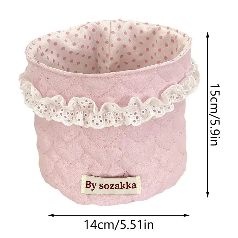 Rosa gepolsterter Stoff-Aufbewahrungskorb mit weißem Spitzenbesatz und Polka-Dot-Innenfutter von Sozakka, entworfen für die Organisation im Kinderzimmer.