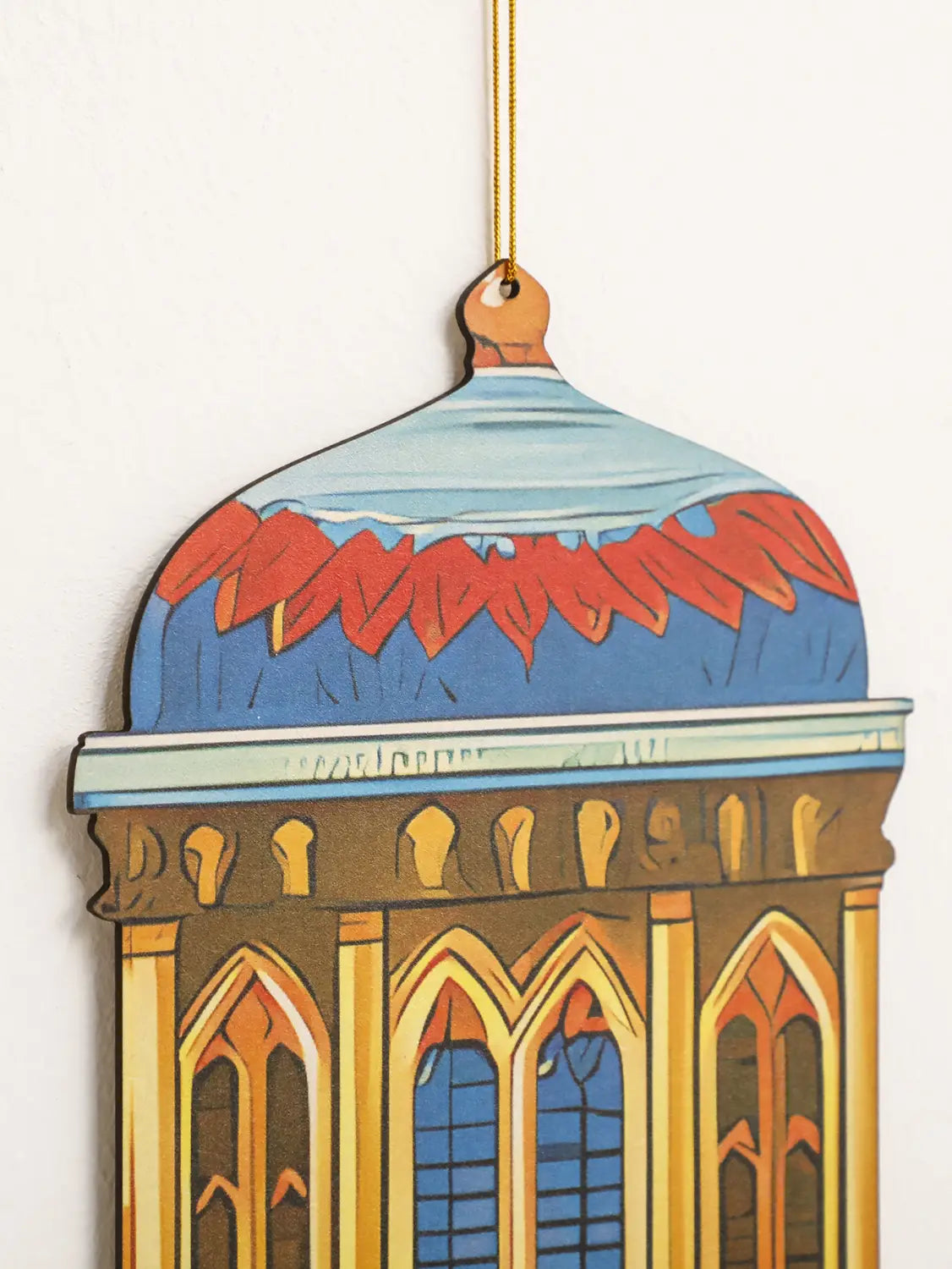 Un farol de luna y estrella para decoración de pared de Ramadán islámico, de madera en tonos variados y con forma de edificio con cubierta abovedada, con detalles pintados en azul y rojo en estilo moderno.