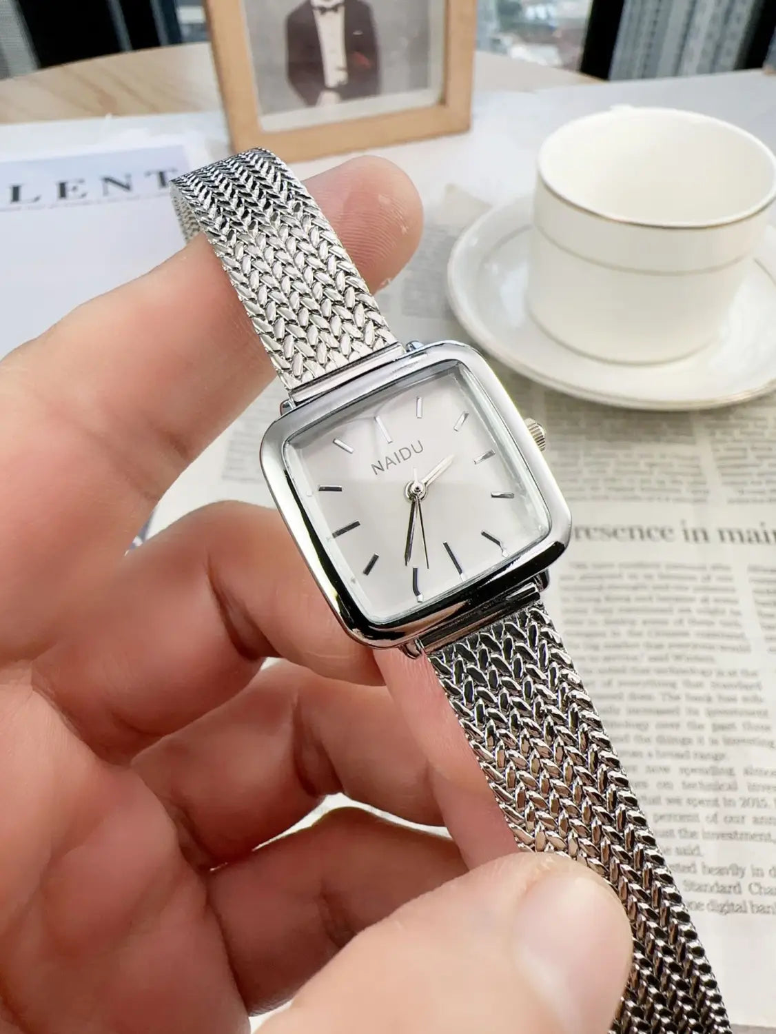Silver mesh bracelet watch with a square face and minimalist black hour markers, designed as a minimalist square quartz watch for women.