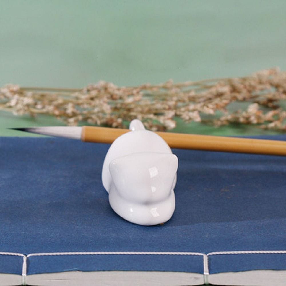 White ceramic dolphin-shaped brush rest designed as a minimalist calligraphy brush holder.