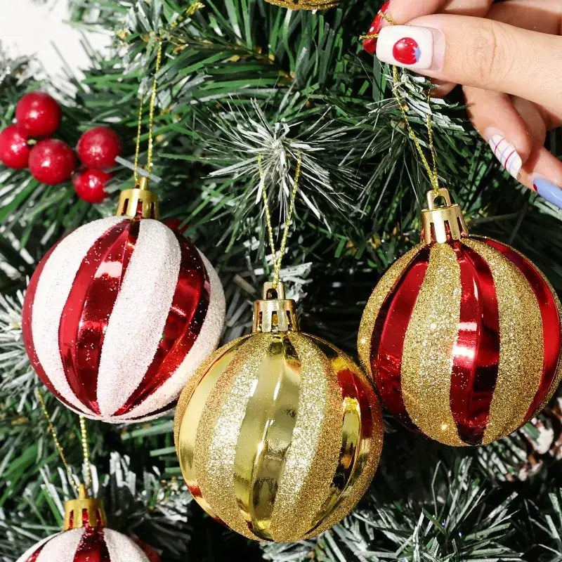 shiny red and gold striped christmas ball ornaments with glittery surfaces hanging on a christmas tree in a set of six 6cm decorations