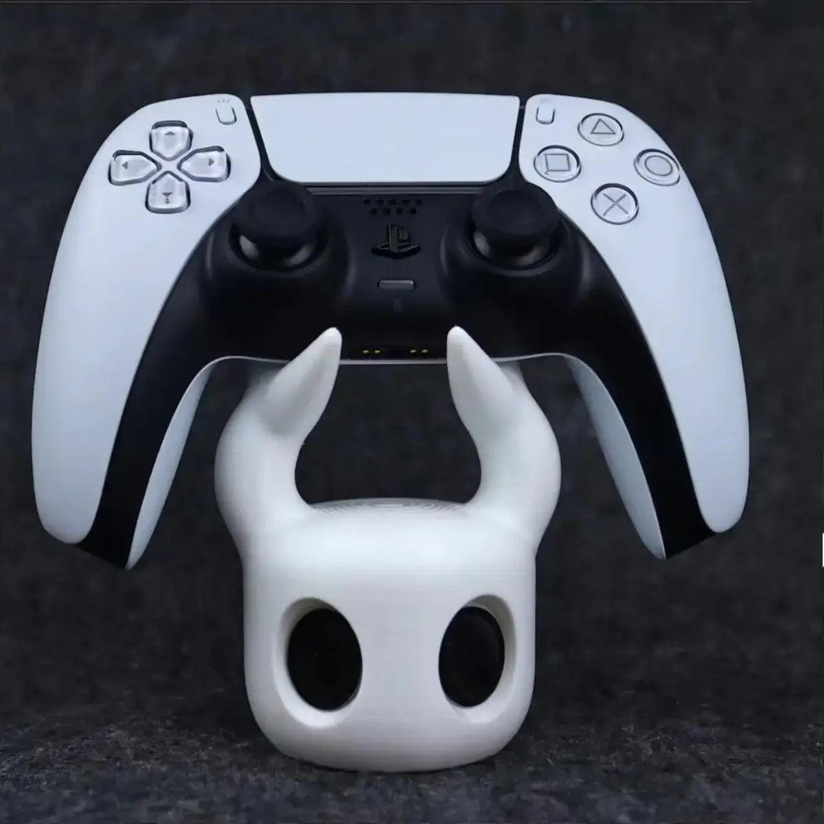 white plastic skull knight game controller stand holding a white and black playstation 5 dualsense controller designed for ps5