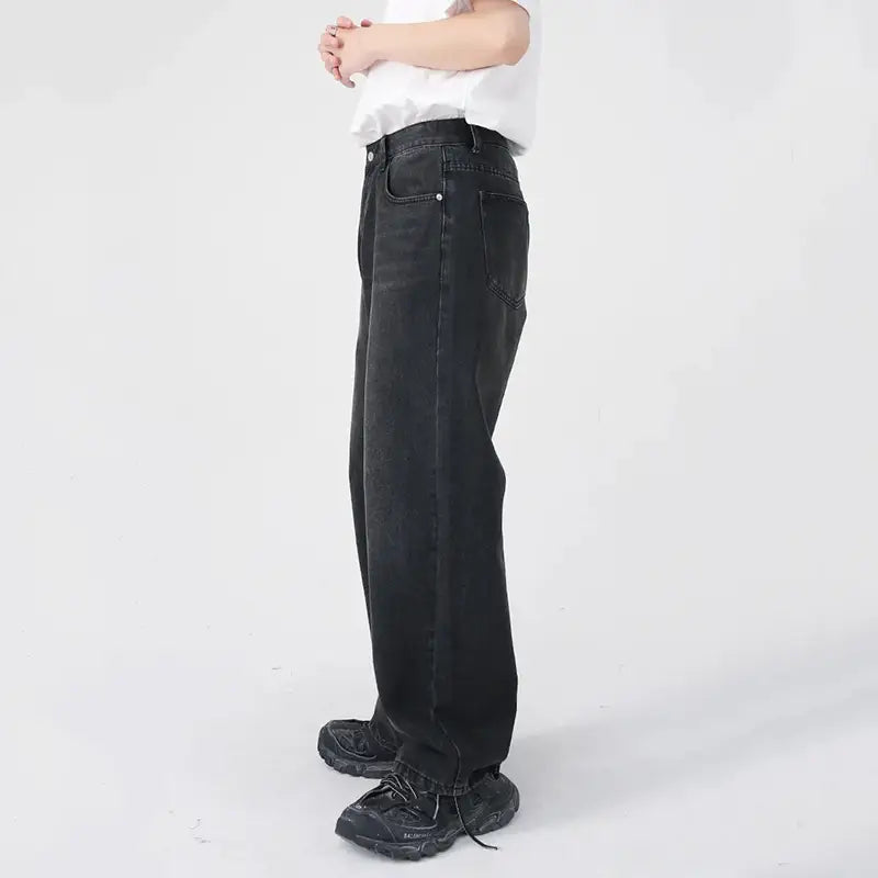 Herren schwarze Wide-Leg-Denim-Jeans mit entspannter Passform und dezenten Ausbleich-Details auf schwarzem Denim-Gewebe.