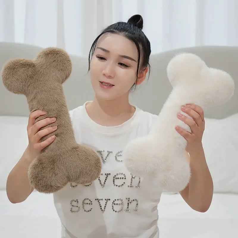 Soft plush dog bone shape plush pillows in tan and white fluffy textured fabric designed as a kawaii bone shape soft nap cushion