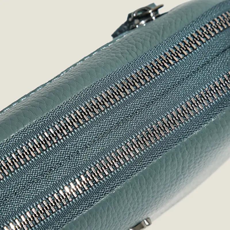 Tealfarbene strukturierte Ledertasche (Clutch) mit doppelten silberfarbenen Reißverschlüssen aus echtem Leder für Damen.